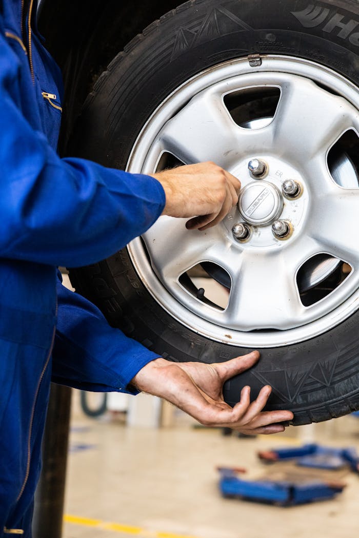creative A mechanic tightens bolts on a car wheel in a professional garage setting.
